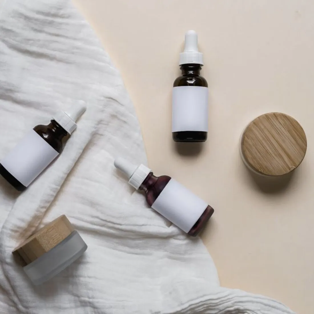 Varios frascos de cosmética dispuestos sobre lino claro